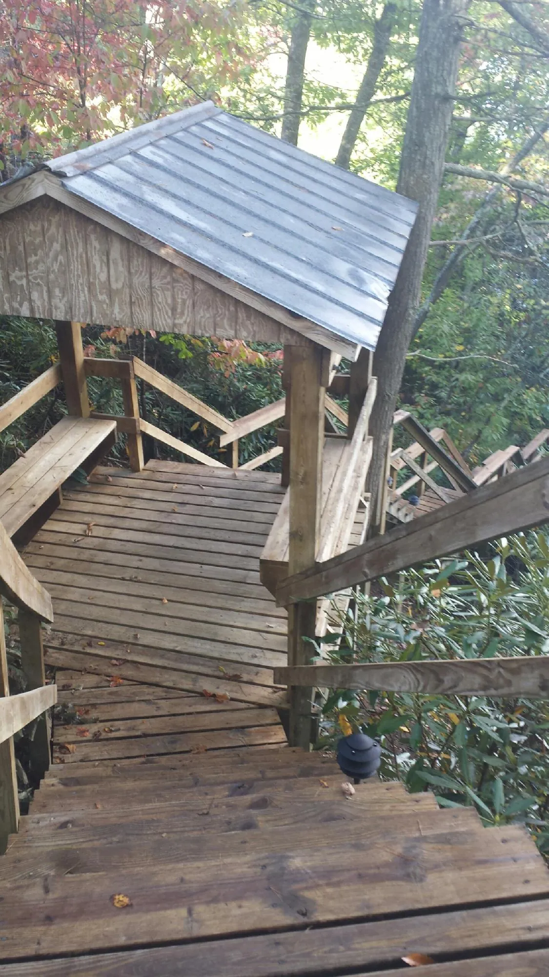 Metal roofed shelter over wooden steps on a wooded walkway — Skylight Repair & Installation work by our crew in Hot Springs