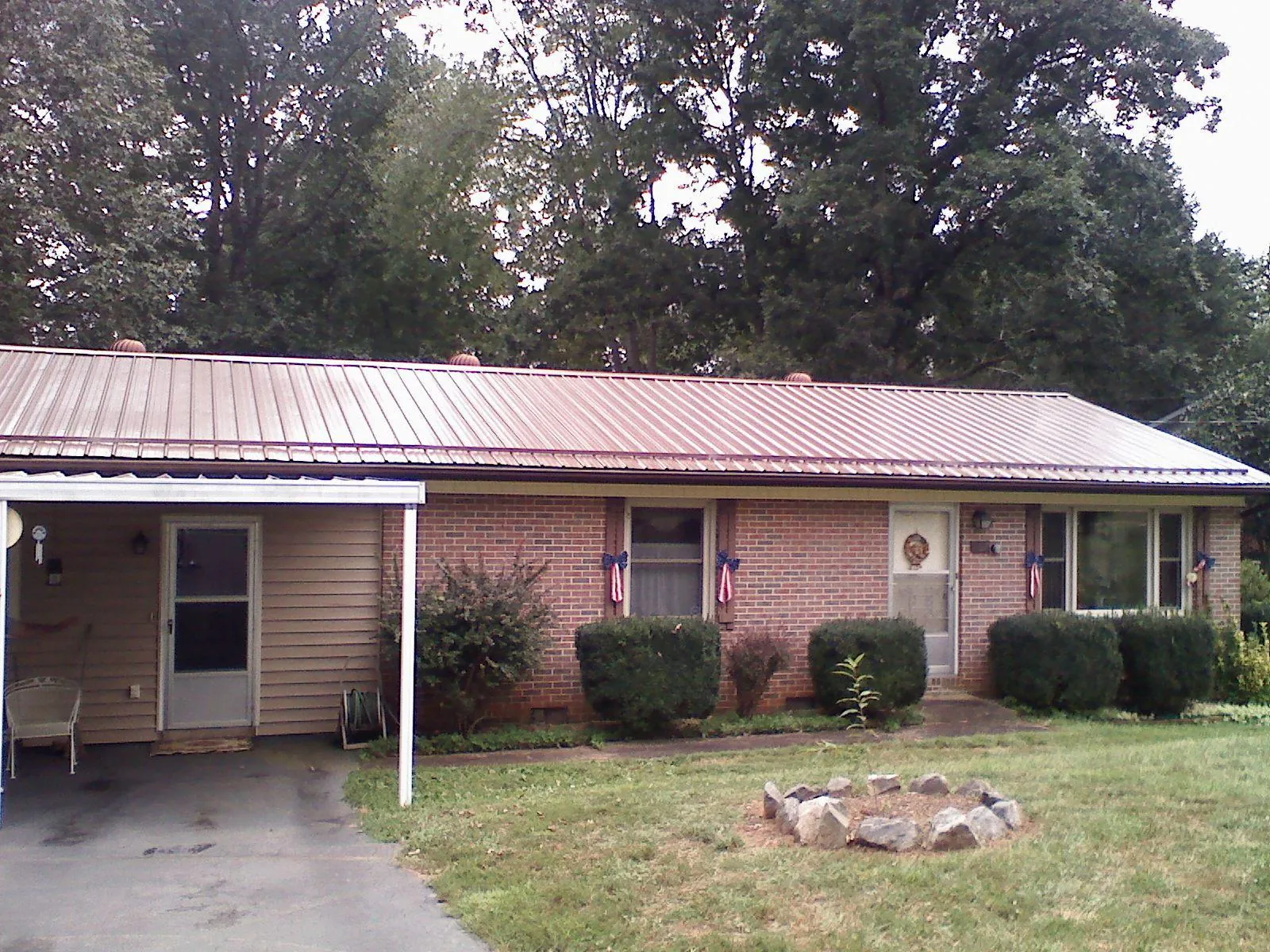Bronze metal roof and carport on a brick ranch home — Roof Repair work by our crew in Hot Springs
