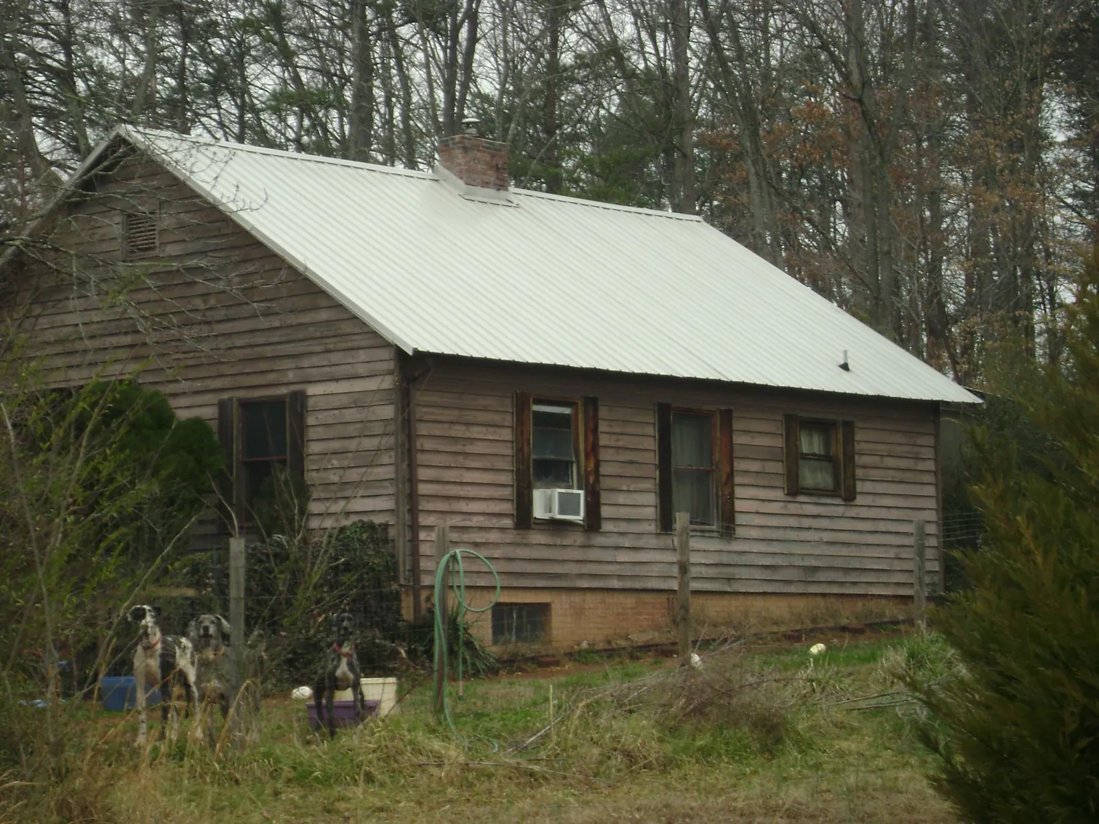 White metal roof on an old wood sided farmhouse, from a Metal Roof Installation job in Hot Springs